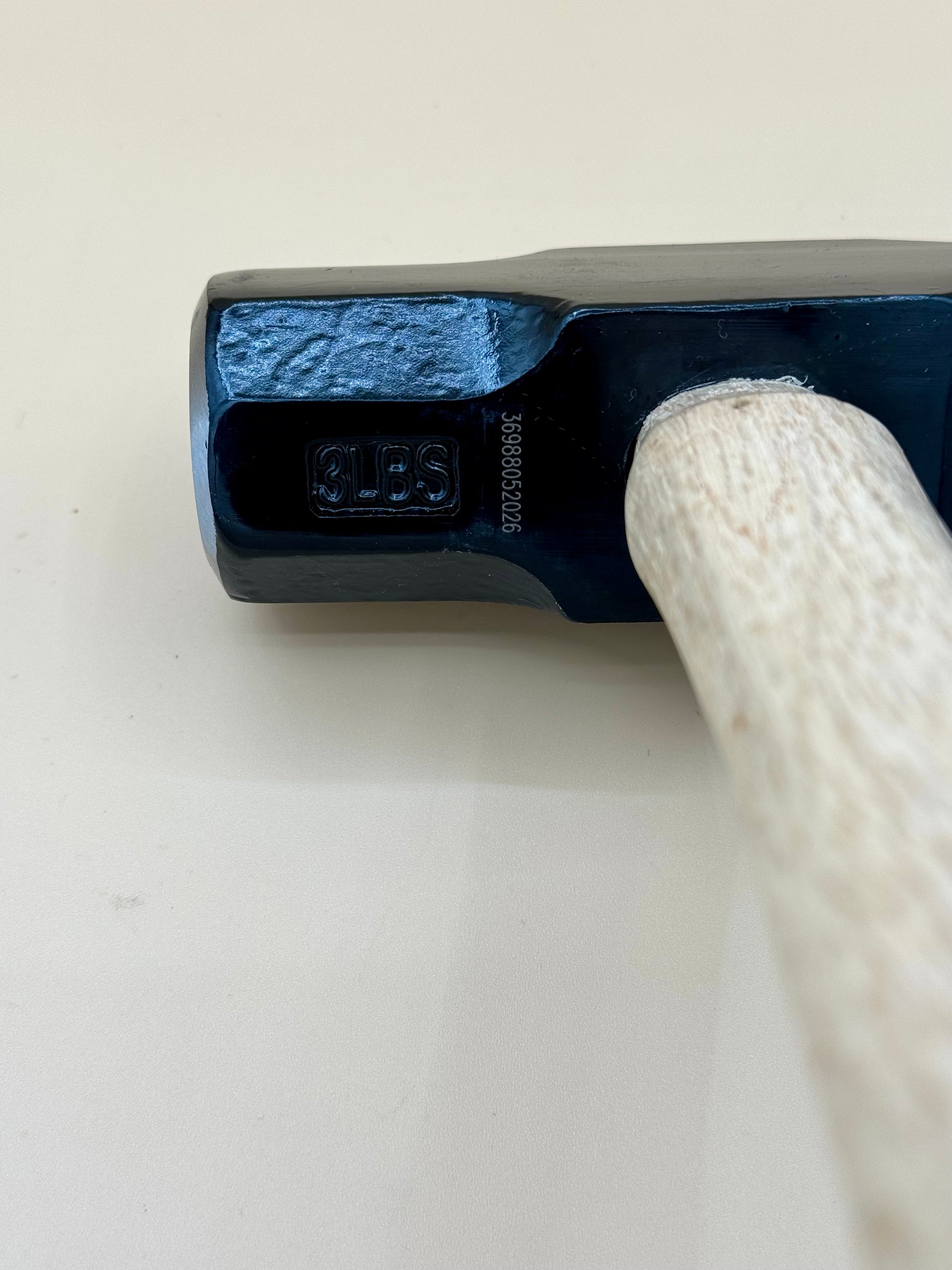 Lost in the Woods Engraved Cross Pein Hammer - Bigfoot Edition - Close-up of stamped black cross pein hammer head and hardwood handle joint — His Word Designs