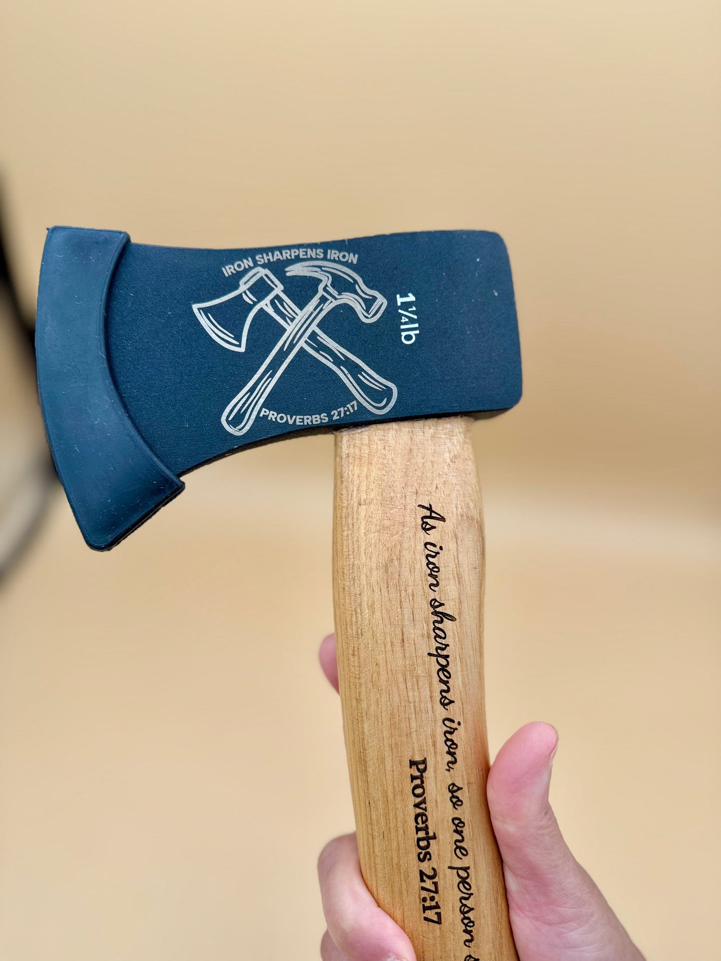 Iron Sharpens Iron Engraved Hickory Camp Axe (Proverbs 27:17) - Close handheld view of Iron Sharpens Iron axe head and Scripture-engraved hickory handle — His Word Designs