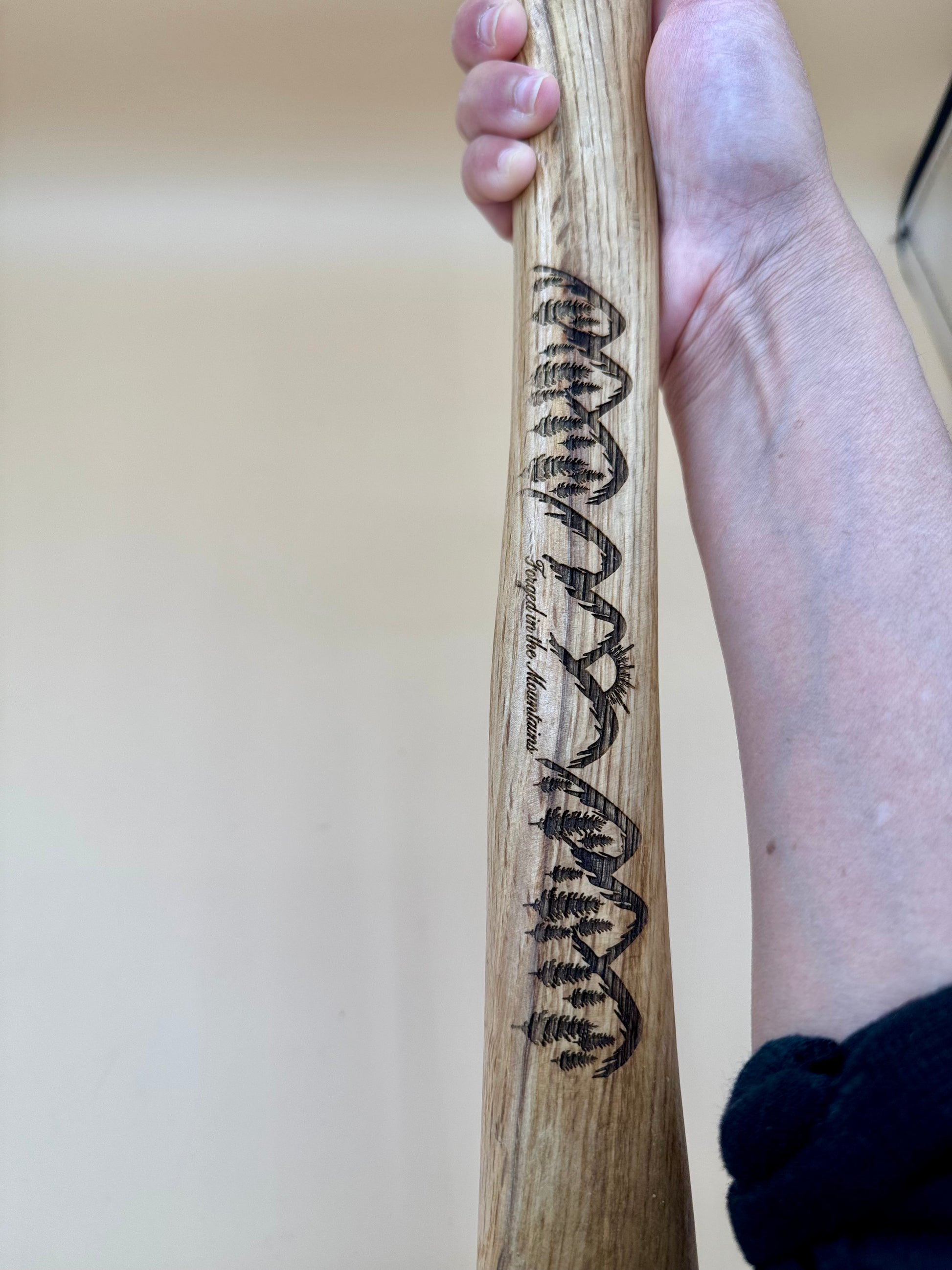 Forged in the Mountains Engraved Claw Hammer - Mountain Pine Edition - Handheld close-up of mountain pine engraving on a hardwood claw hammer handle — His Word Designs